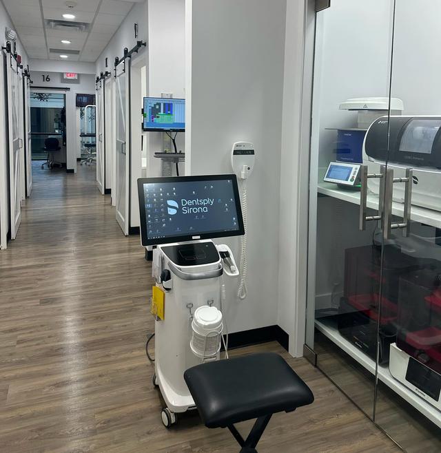 a dental office with a stool and a monitor that says dentistry studio