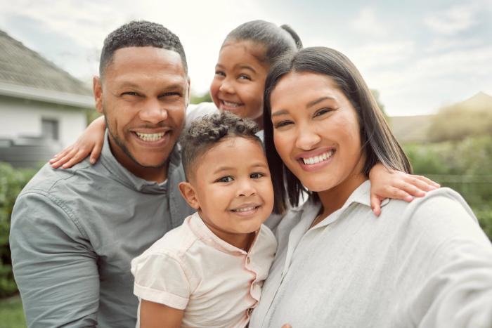 a family is posing for a picture together and smiling for the camera .
