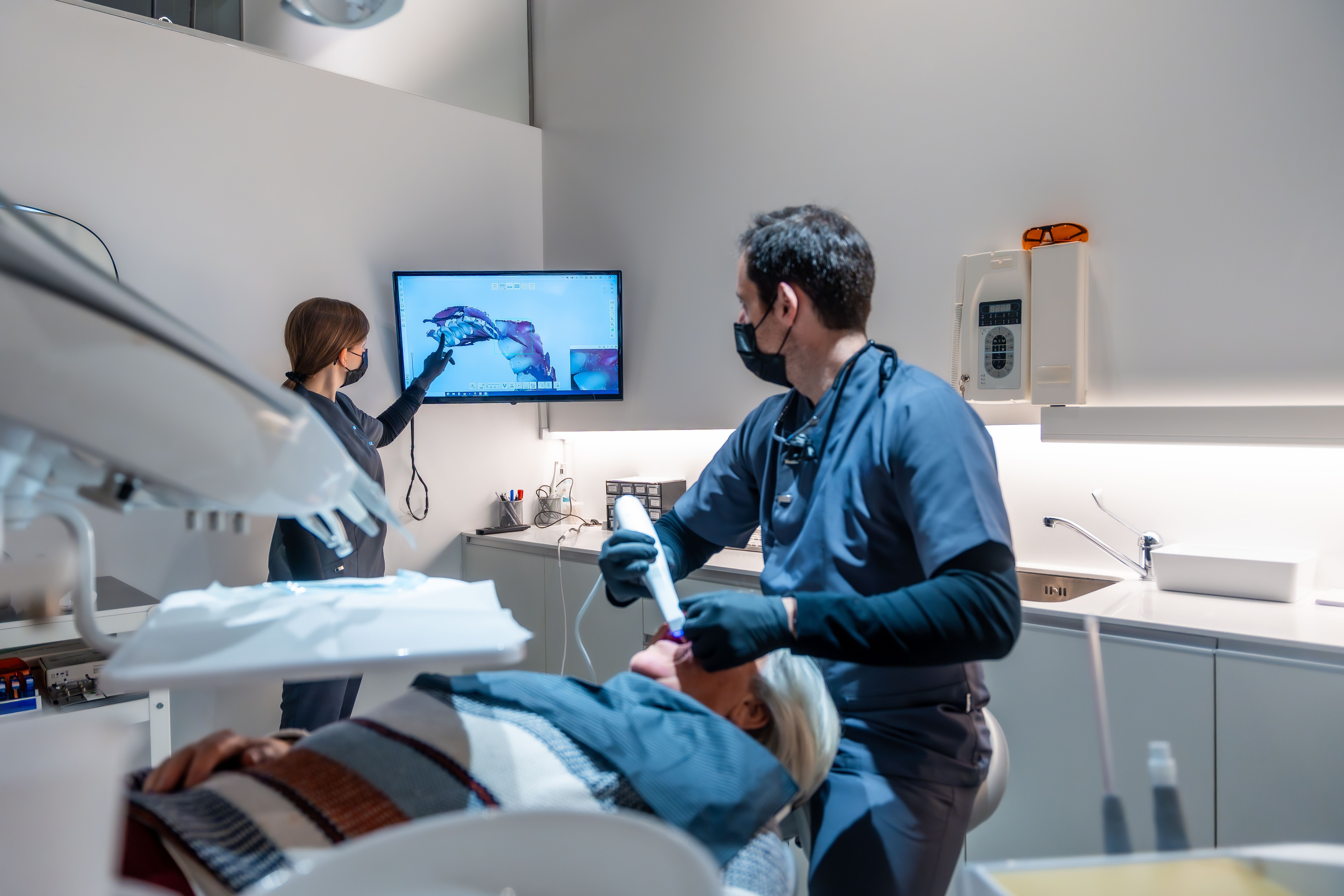 a dentist is examining a patient 's teeth in a dental office .