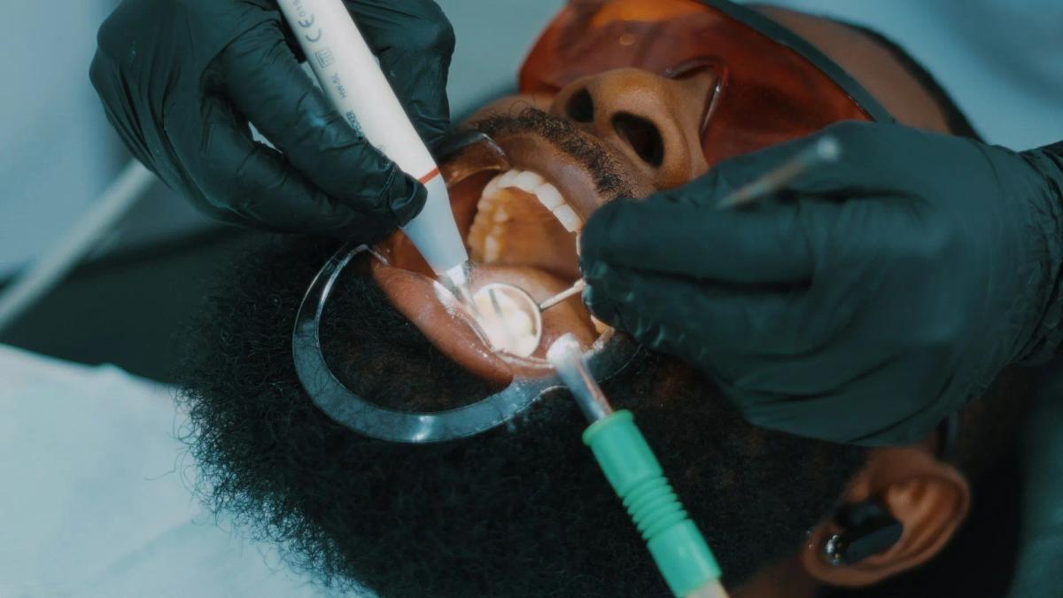 a man is getting his teeth examined by a dentist .