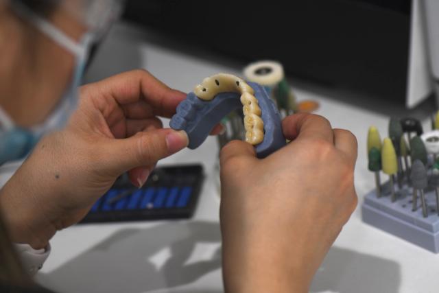 a dentist is working on a model of a person 's teeth .
