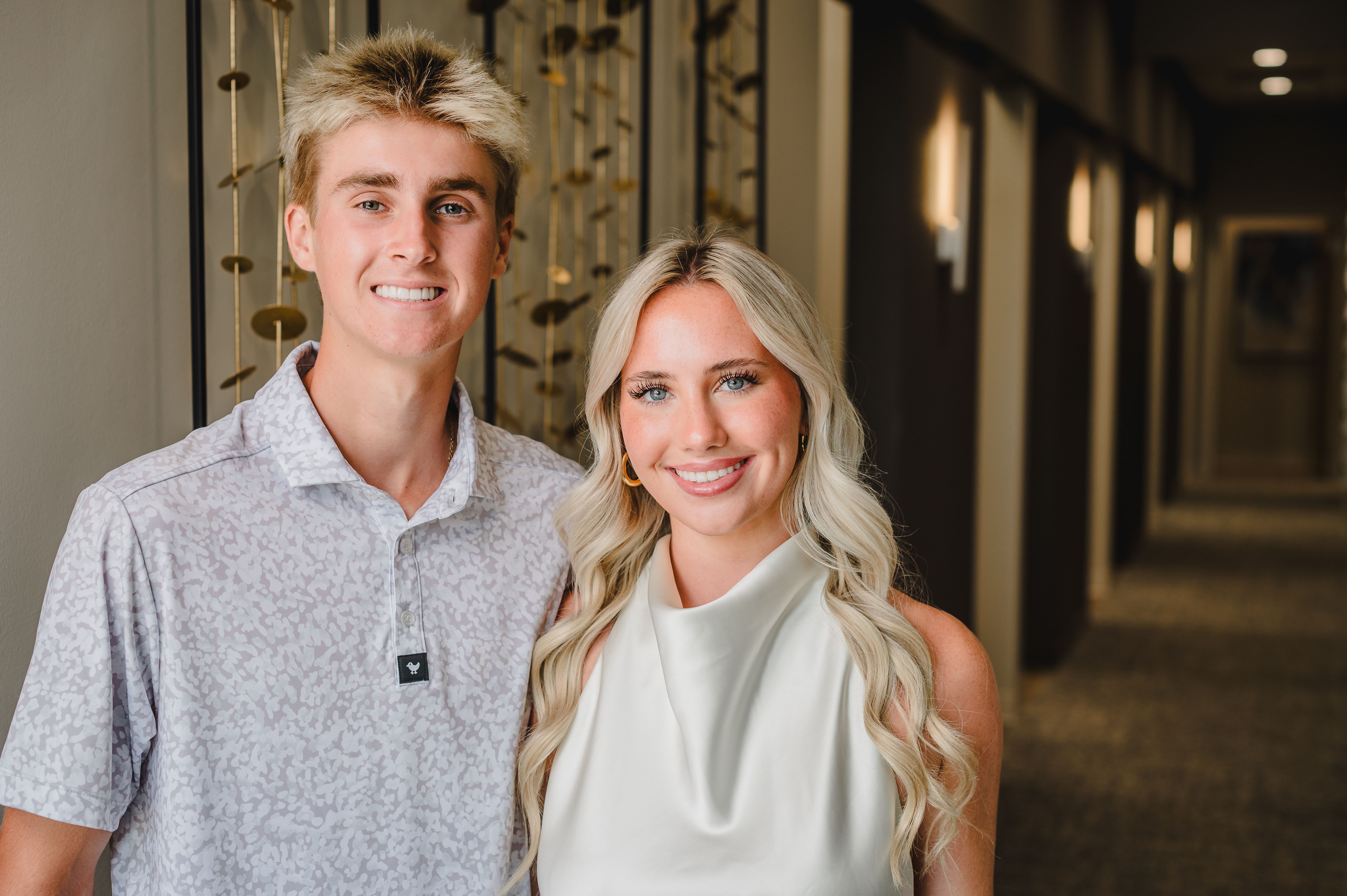 a man and a woman are posing for a picture in a hallway .