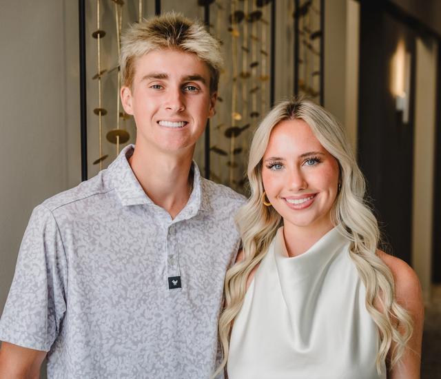 a man and a woman are posing for a picture in a hallway .