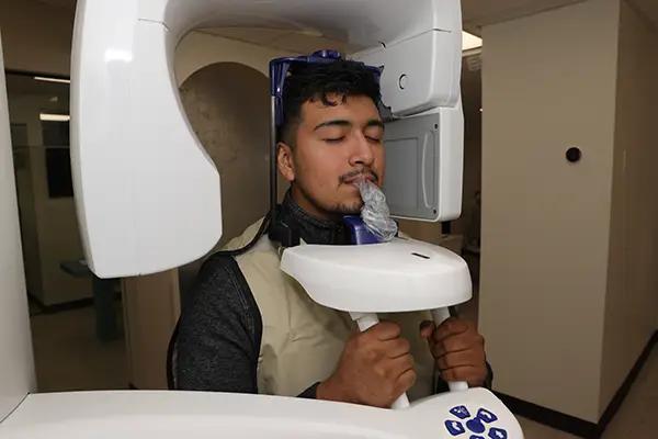 a man is getting an x-ray of his teeth in a dental office .