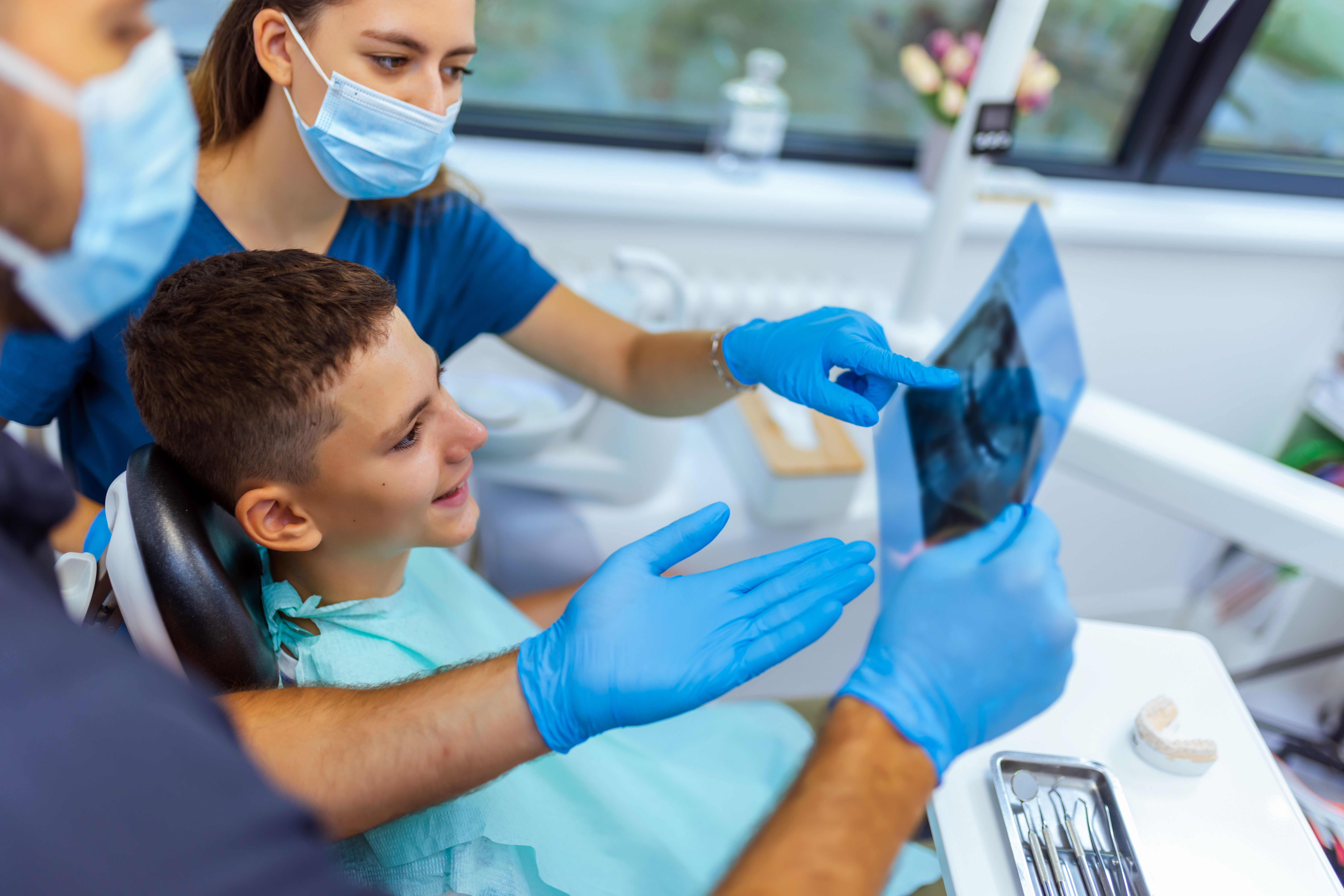 Dental professionals showing a young patient a dental X-ray.