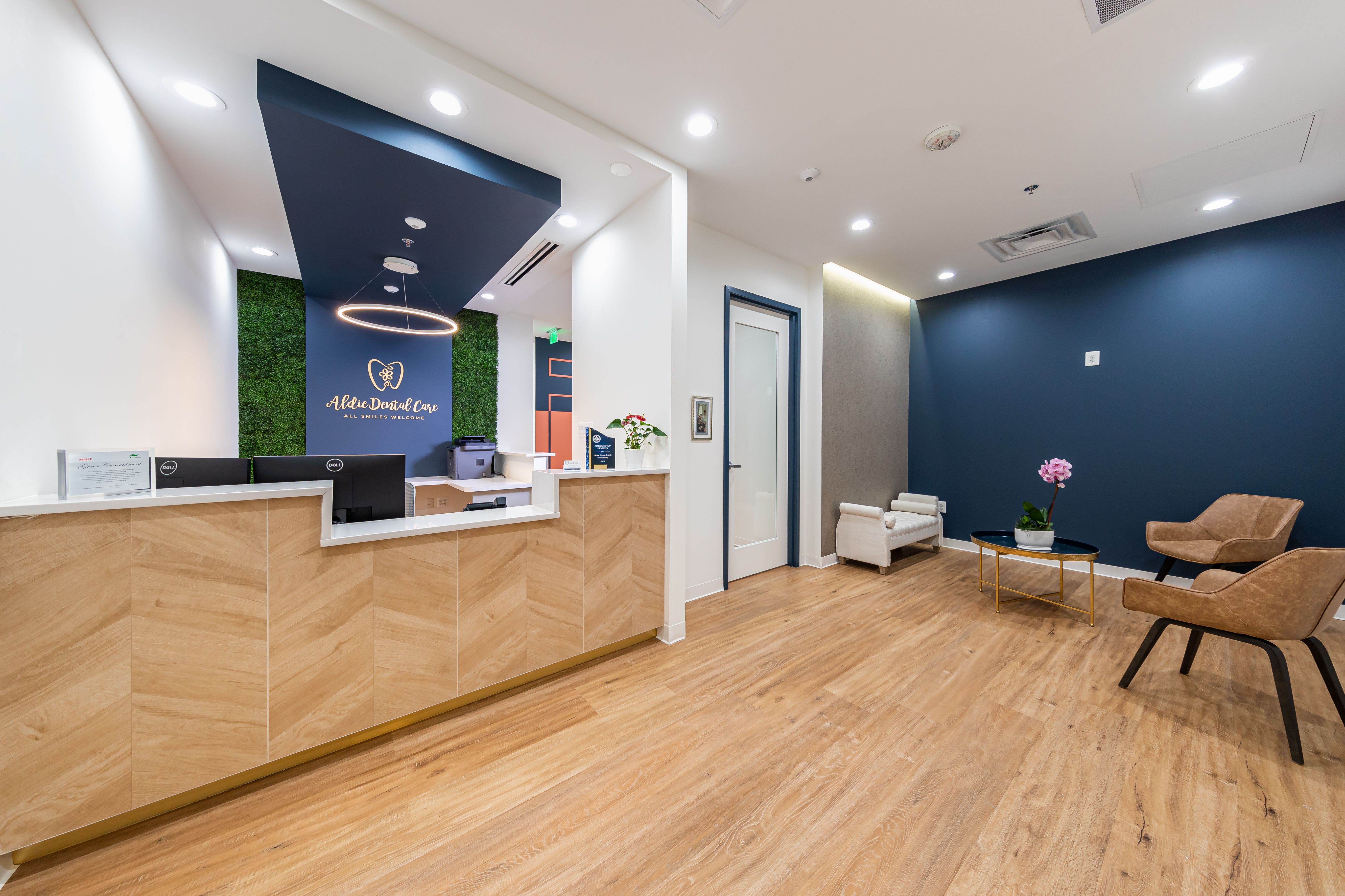 a dental office with a wooden reception desk and chairs .