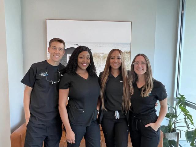 a group of dental assistants are posing for a picture together .
