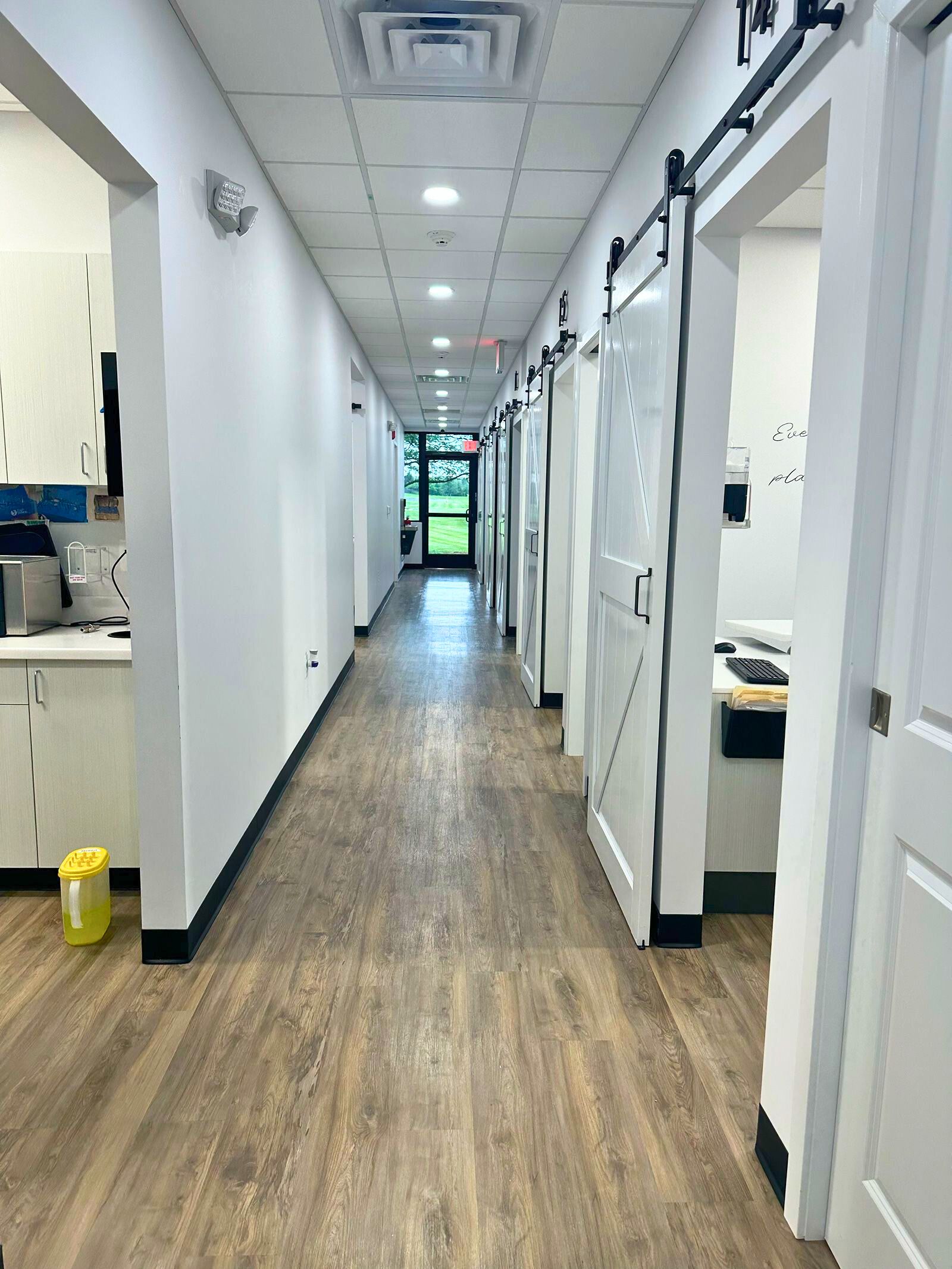 a long hallway in a dental office with sliding barn doors