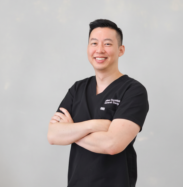 a man wearing a black scrub top that says dental surgery