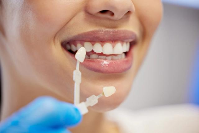 a woman is getting her teeth examined by a dentist .