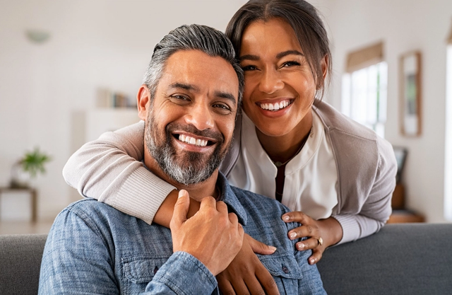 a man and woman are posing for a picture and smiling