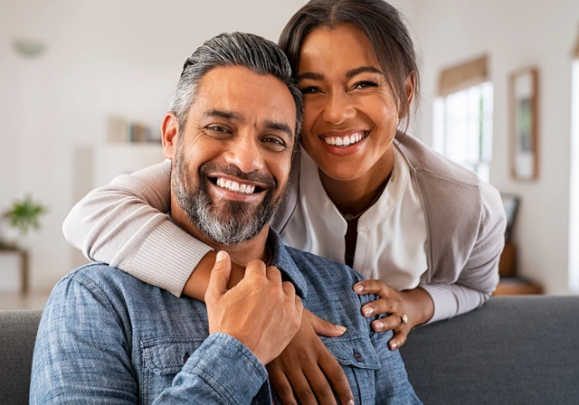 a man and woman are posing for a picture and smiling