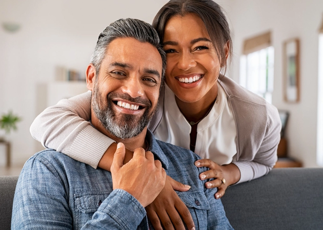 a man and woman are posing for a picture and smiling