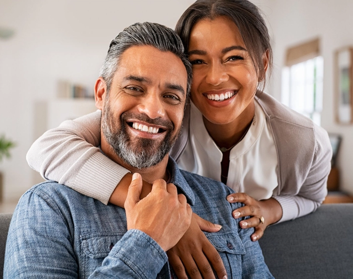a man and woman are posing for a picture and smiling