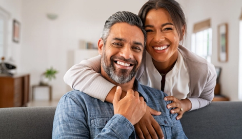 a man and woman are posing for a picture and smiling