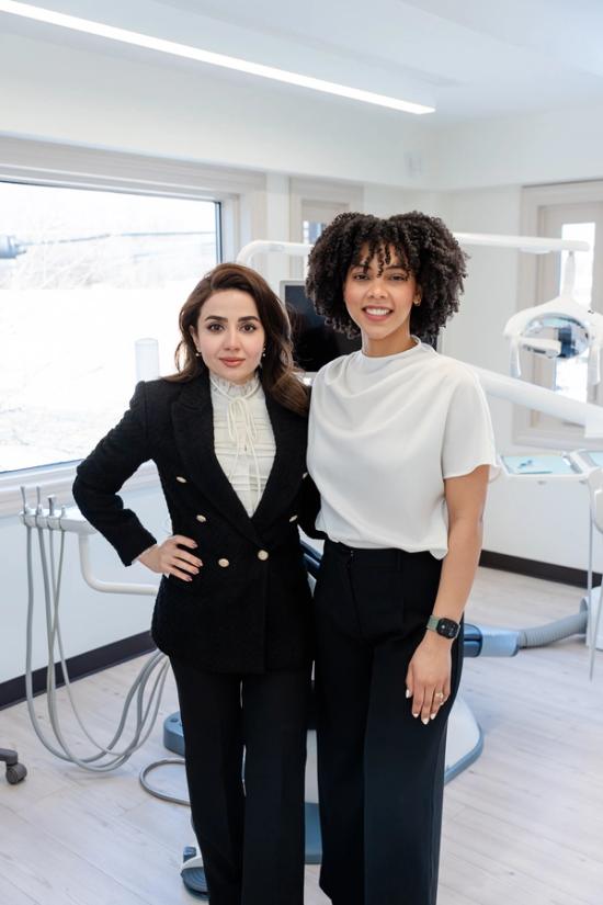 two women standing next to each other in a dental office