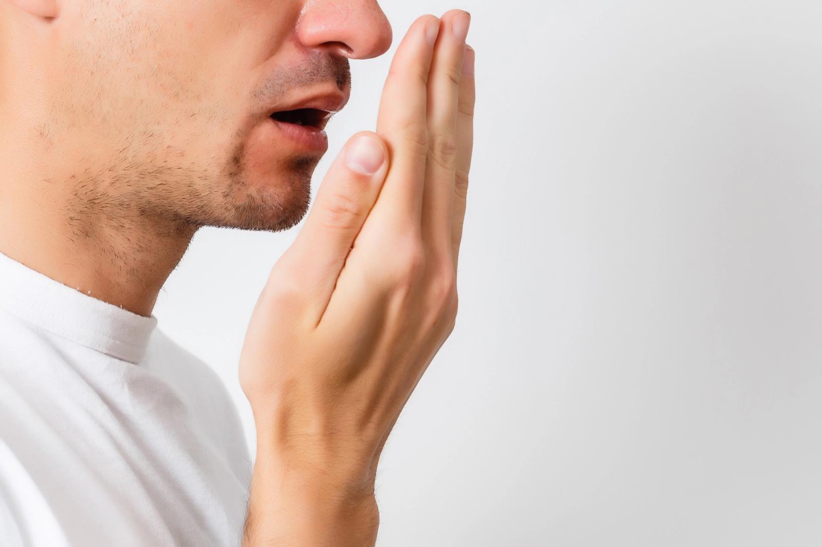 a man is covering his mouth with his hand .