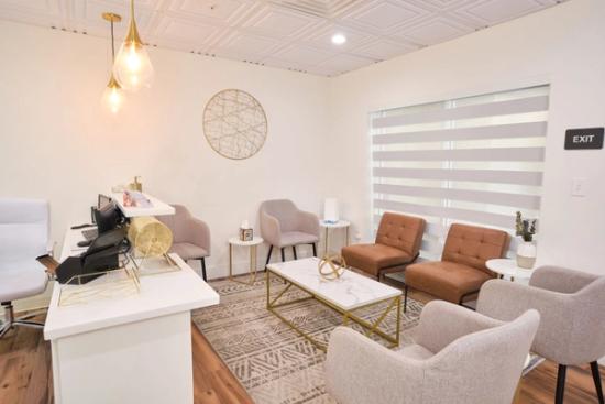 a dental office waiting room with blue chairs and a white counter .