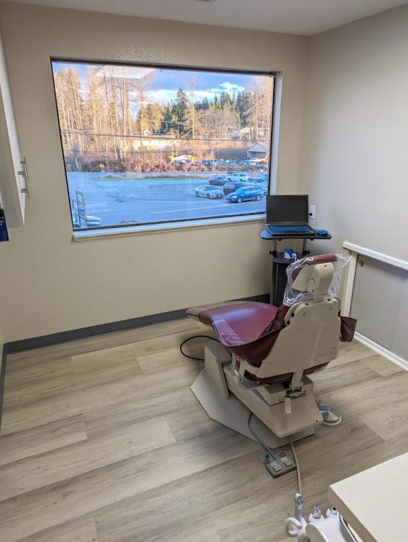a dental office with a dental chair and a large window .