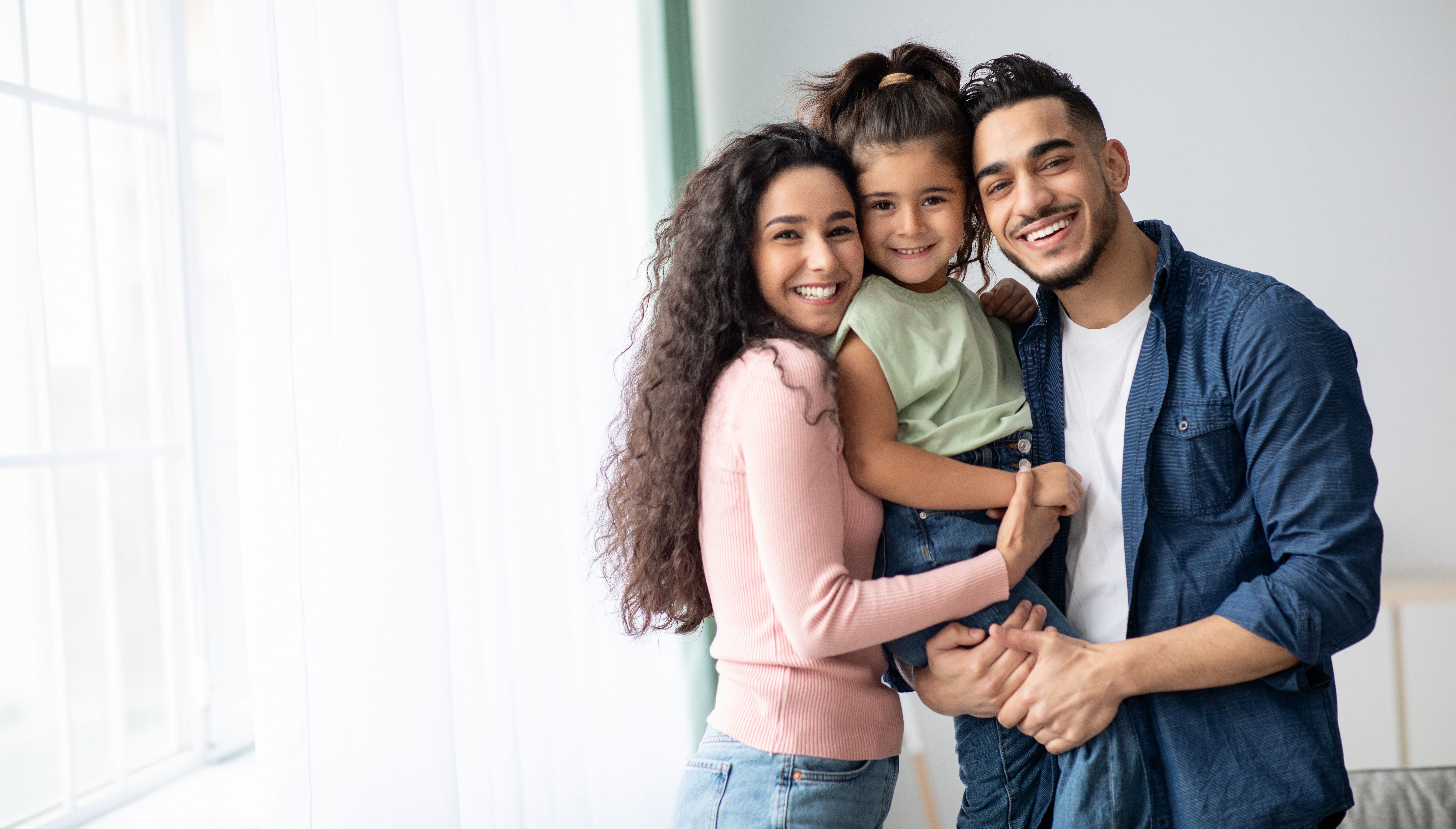 a family is posing for a picture together in a living room .