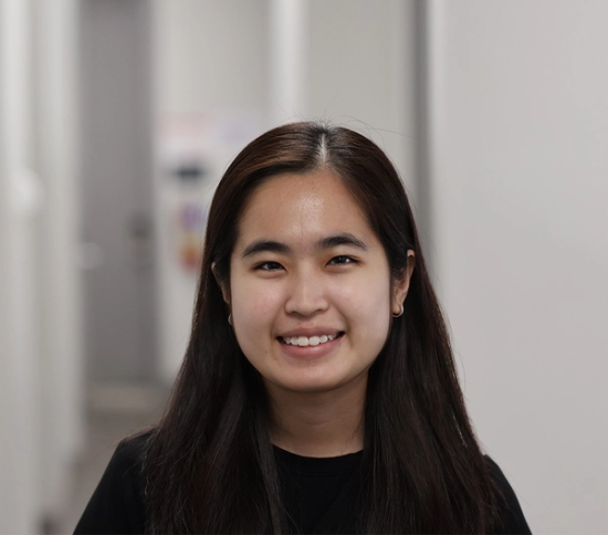 a woman in a black shirt smiles for the camera