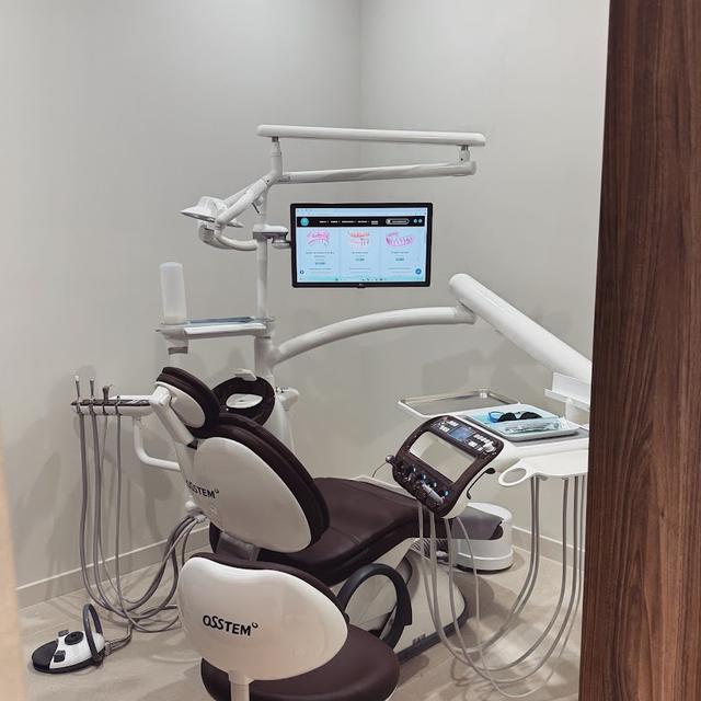 a dental chair with a monitor on top of it in a dental office .