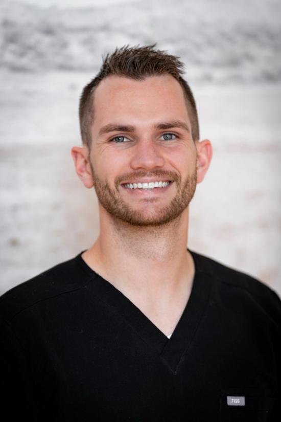 a man wearing a black scrub top with the letters fox on it