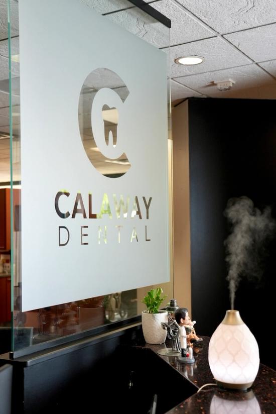 The Calaway Dental logo and name on a frosted glass sign, with a diffuser emitting mist on a counter.