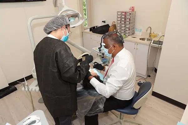 a dentist is working on a patient 's teeth in a dental office .