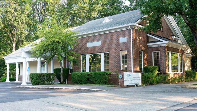 a large brick building with a lot of windows and trees in front of it .