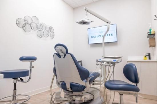 a dental office with a dental chair and a television on the wall .
