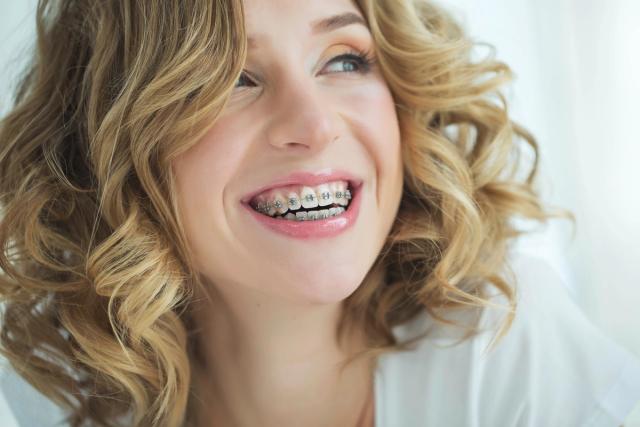a close up of a woman with braces on her teeth smiling .