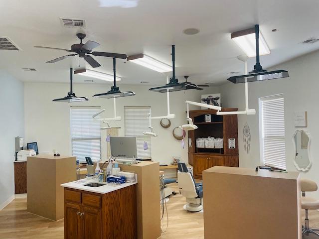 a dental office with a lot of dental equipment and ceiling fans .