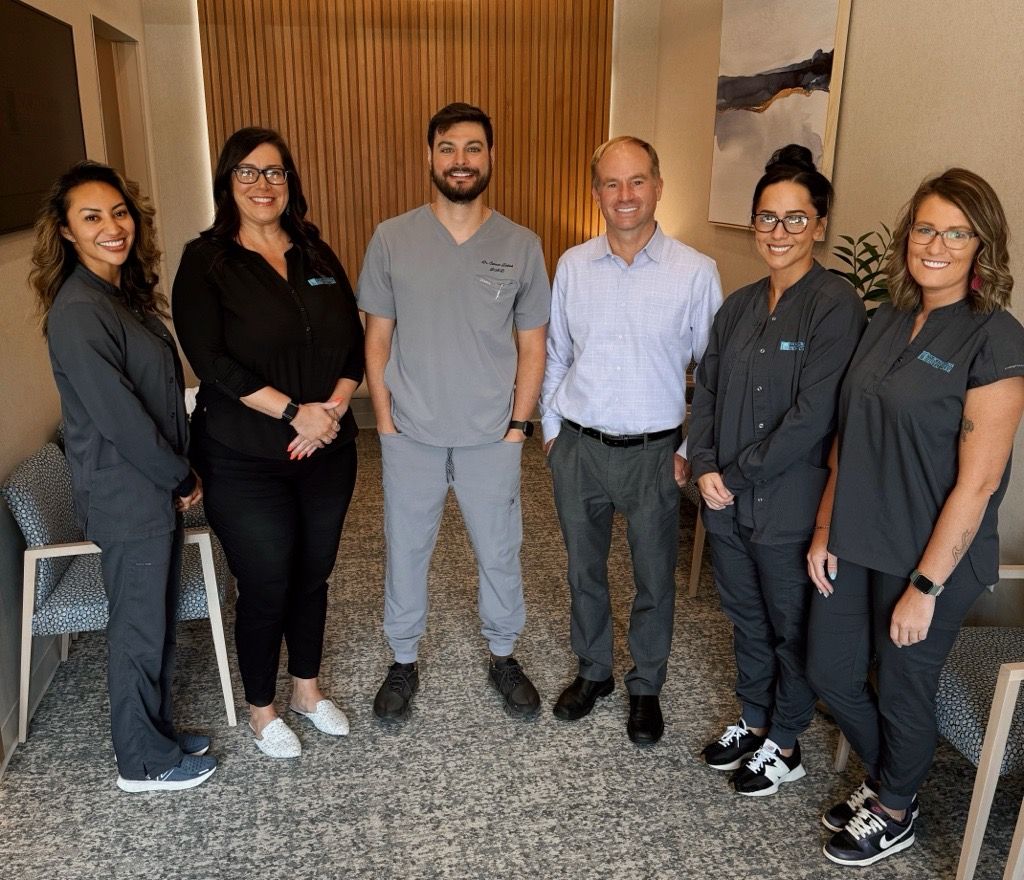 a group of doctors and nurses are posing for a picture in a waiting room .