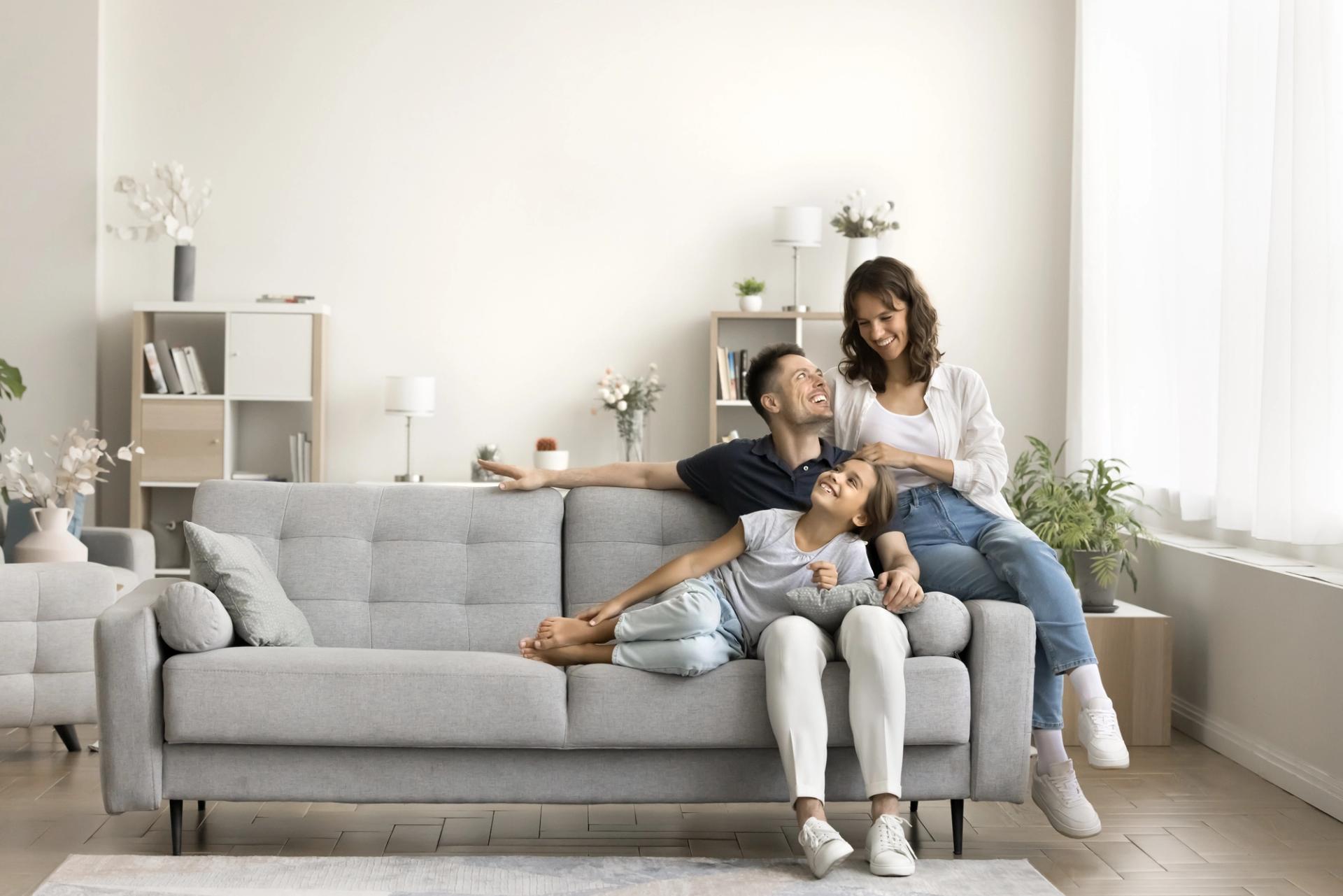 a family is sitting on a couch in a living room .