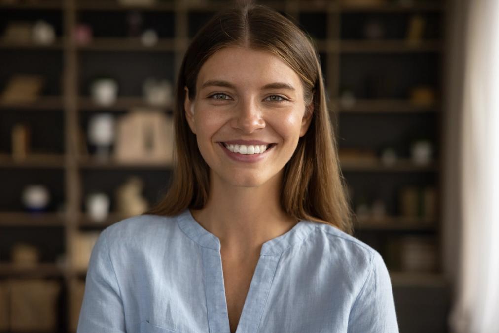a close up of a smiling woman in a blue shirt .