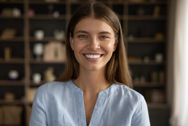 a close up of a smiling woman in a blue shirt .