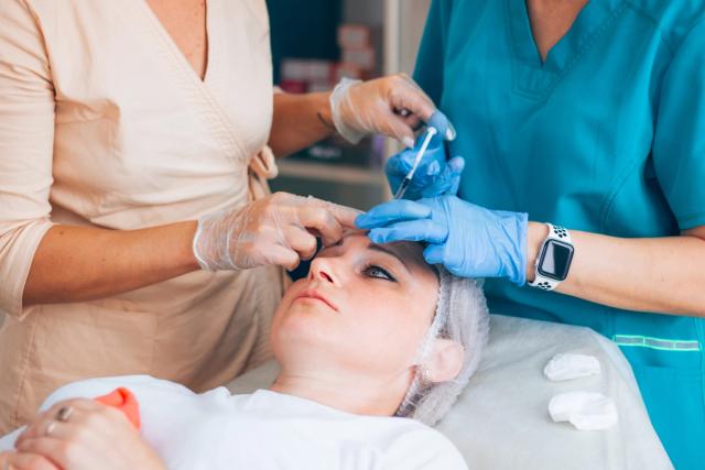 a woman is getting an injection in her face in a beauty salon .