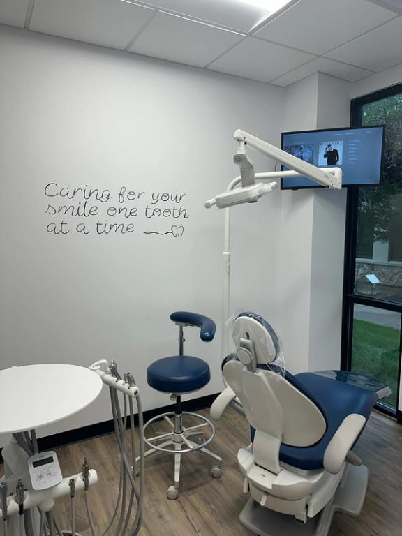 a dental office with a sign on the wall that says caring for your smile one tooth at a time