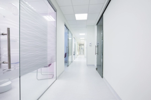 a hallway in a hospital with a glass door