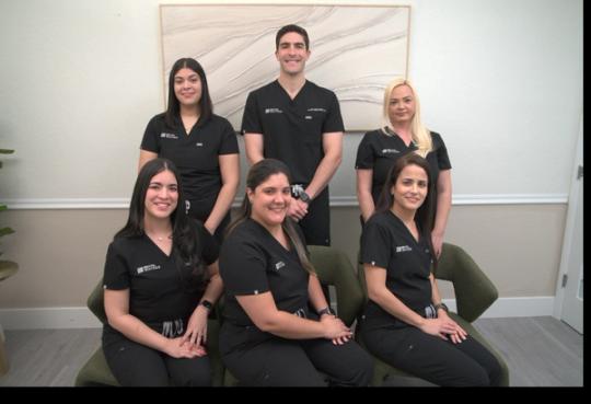 a man in a black scrub top with the name dr. julian franco on it