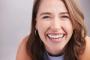 a close up of a woman 's face with a big smile on her face .