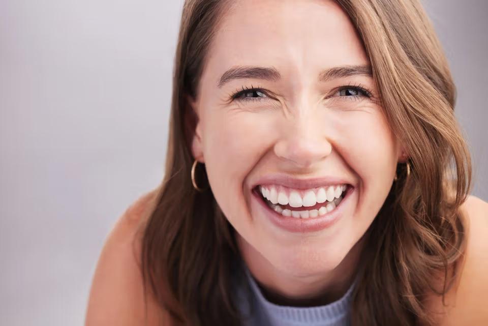 a close up of a woman 's face with a big smile on her face .