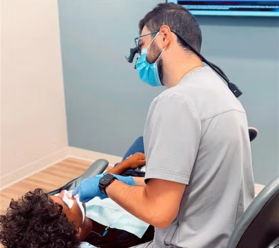 a dentist examines a child 's teeth in a dental chair