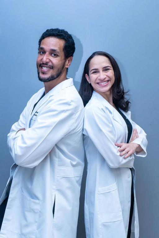 a man and a woman standing back to back with their arms crossed