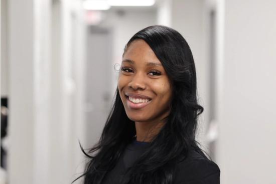 a woman is smiling for the camera in a hallway .