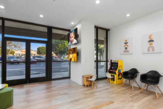 a waiting room at a dental office with a pac man arcade machine .