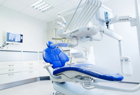 an empty dental office with a blue dental chair