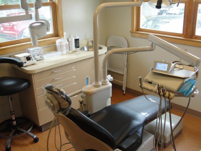 a dental office with a dental chair and a sink .
