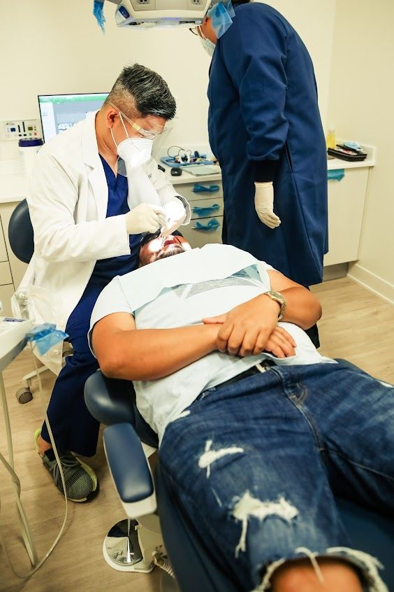 a man is getting his teeth examined by a dentist